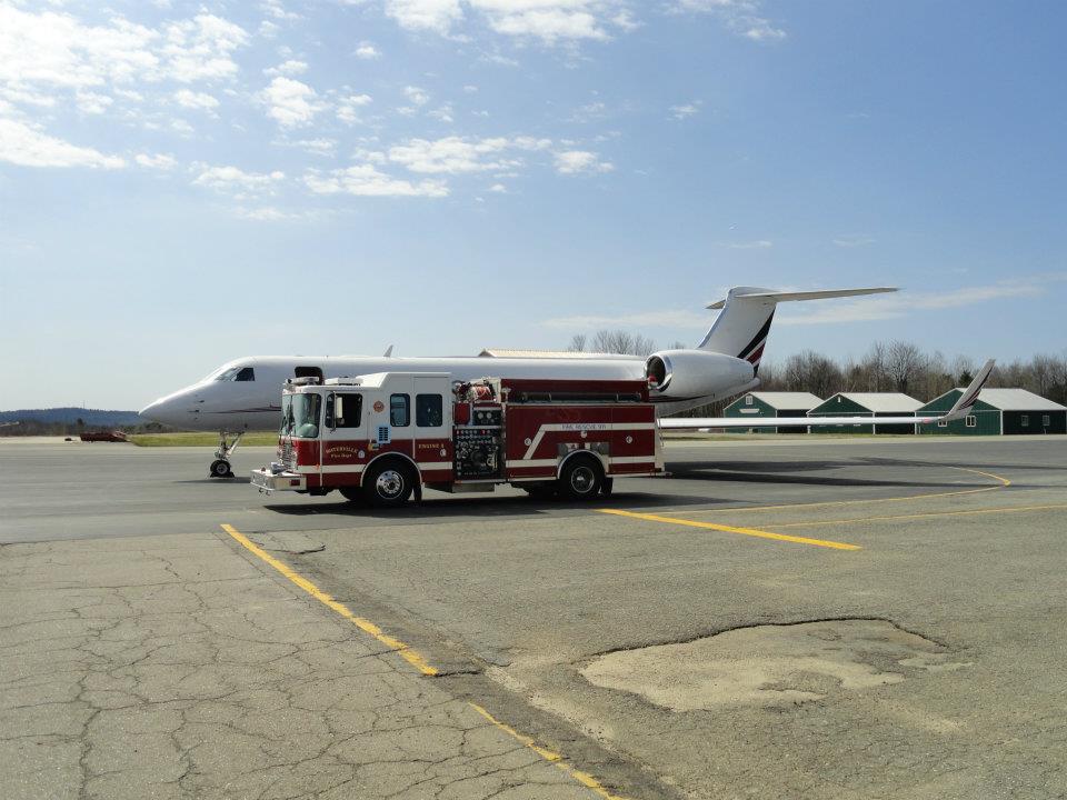 Fire Truck Parked Next to Jet